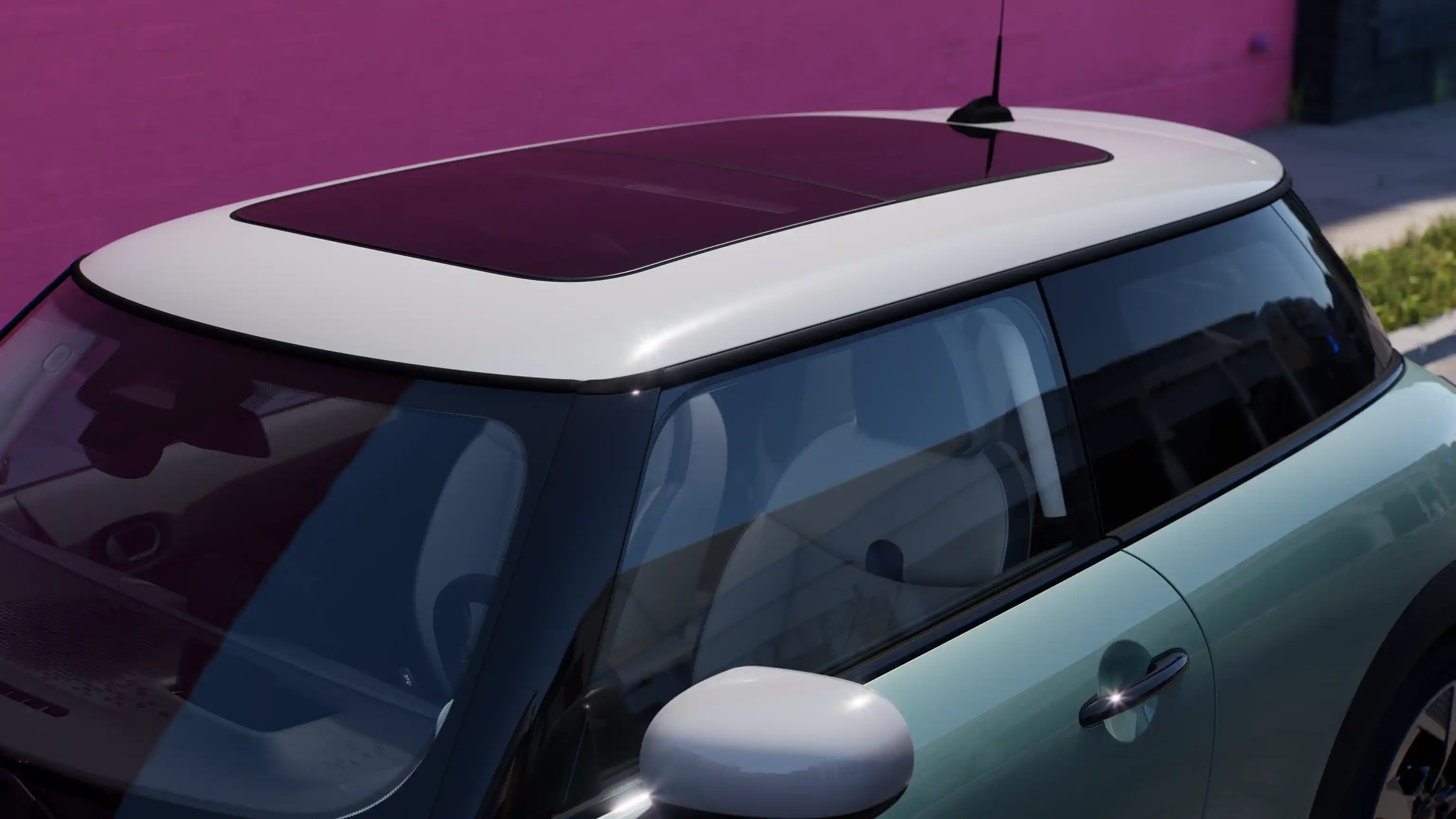 Widok z góry na MINI Cooper w kolorze Ocean Wave Green z kontrastującym dachem z dużym przeszkleniem.