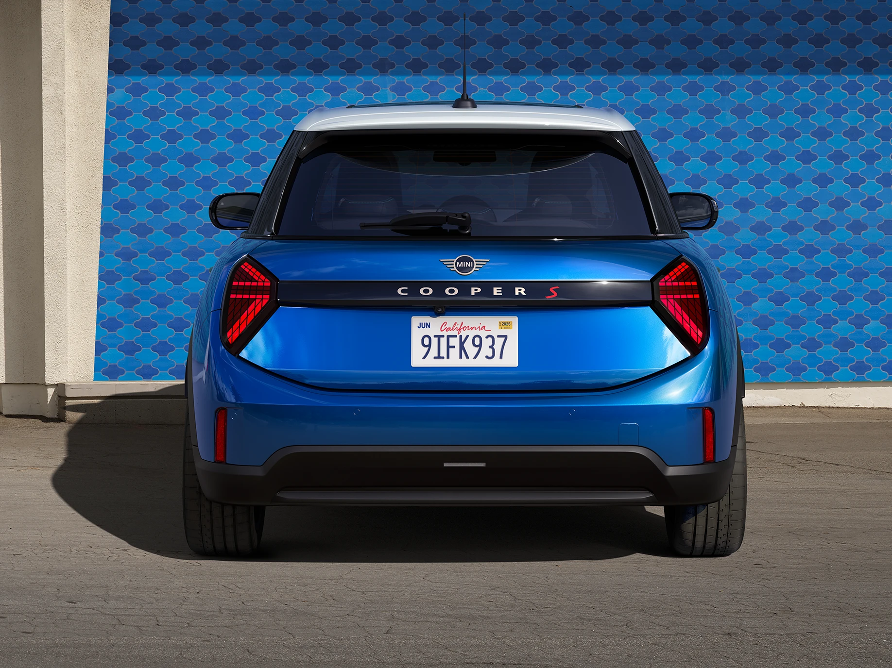 Widok z tyłu na 5-drzwiowe MINI Cooper w kolorze niebieskim Icy Sunshine i niebieski dach Multitone.