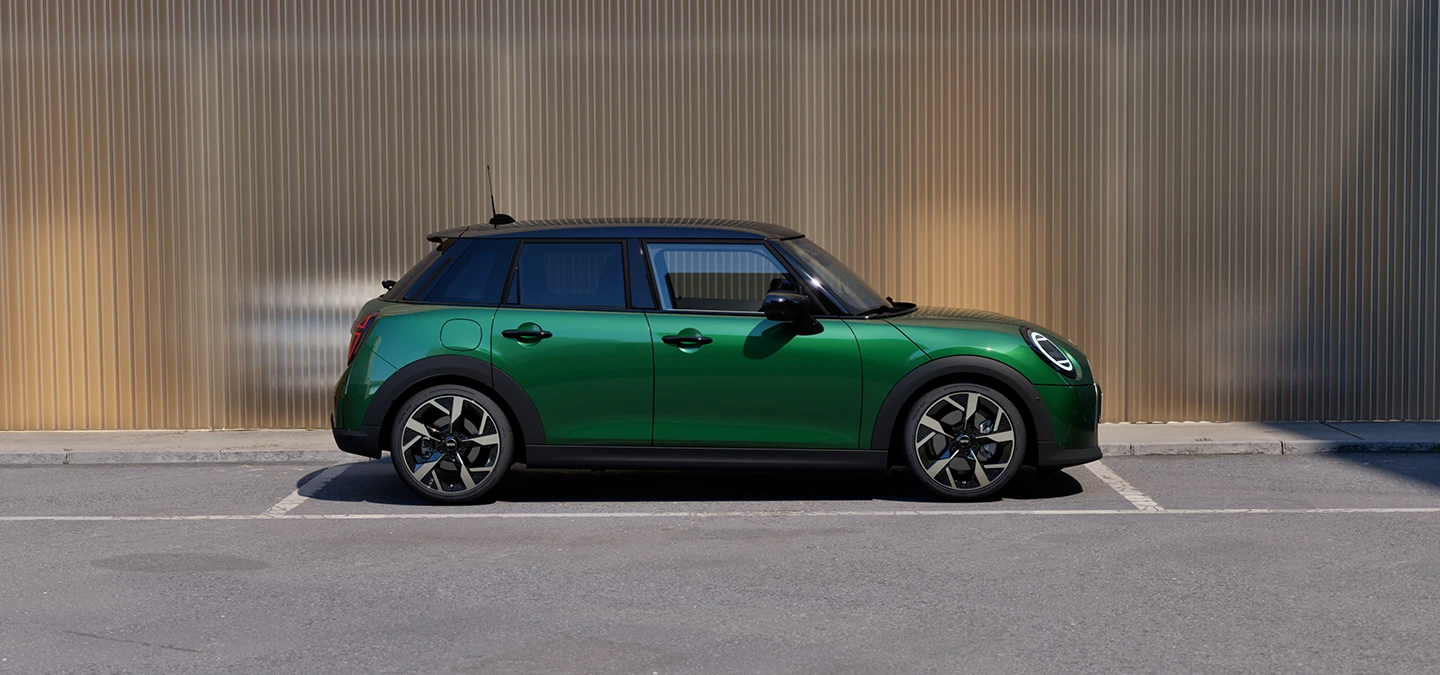 Widok z boku na zaparkowane 5-drzwiowe MINI Cooper w kolorze British Racing Green z czarnym dachem.