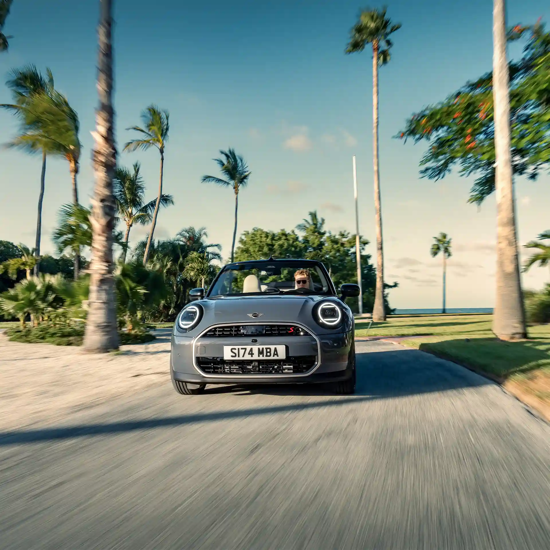 Widok z przodu jadącego MINI Cooper Cabrio w kolorze Copper Grey na ulicy