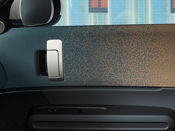 Zbliżenie na stylistykę wnętrza w pełni elektrycznego MINI Countryman skupione na drzwi i deskę rozdzielczą.