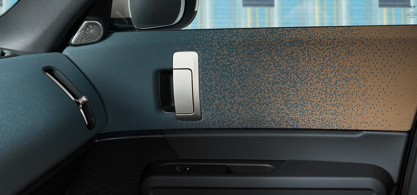 Zbliżenie na stylistykę wnętrza w pełni elektrycznego MINI Countryman skupione na drzwi i deskę rozdzielczą.