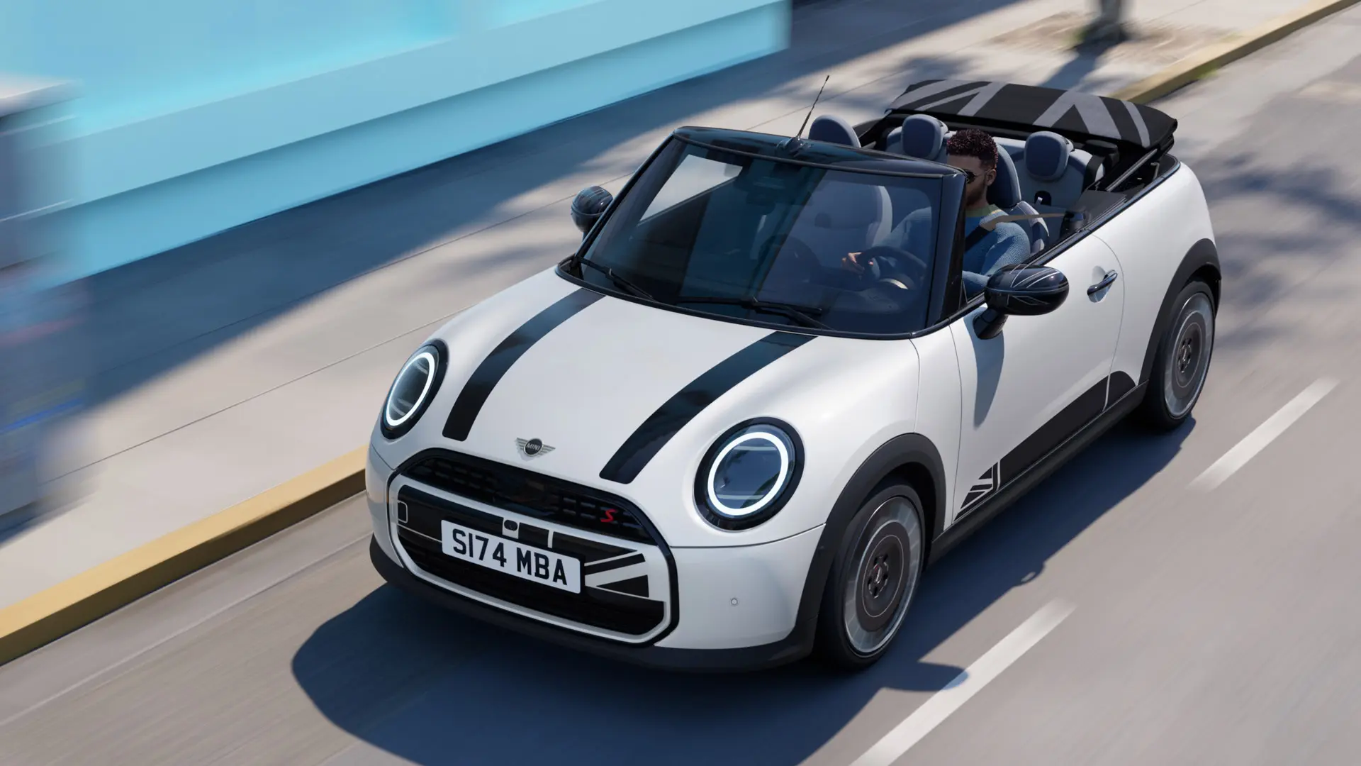 Widok z góry MINI Cabrio w kolorze Nanuq White z czarnymi naklejkami MINI Heritage na masce. 