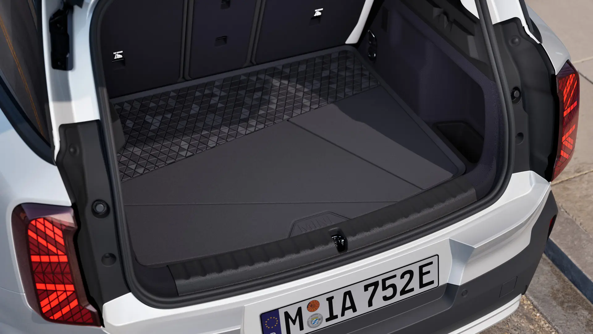 Czarna, dopasowana mata do bagażnika MINI z wysokim rantem dookoła, chroniąca przed brudem i wilgocią.