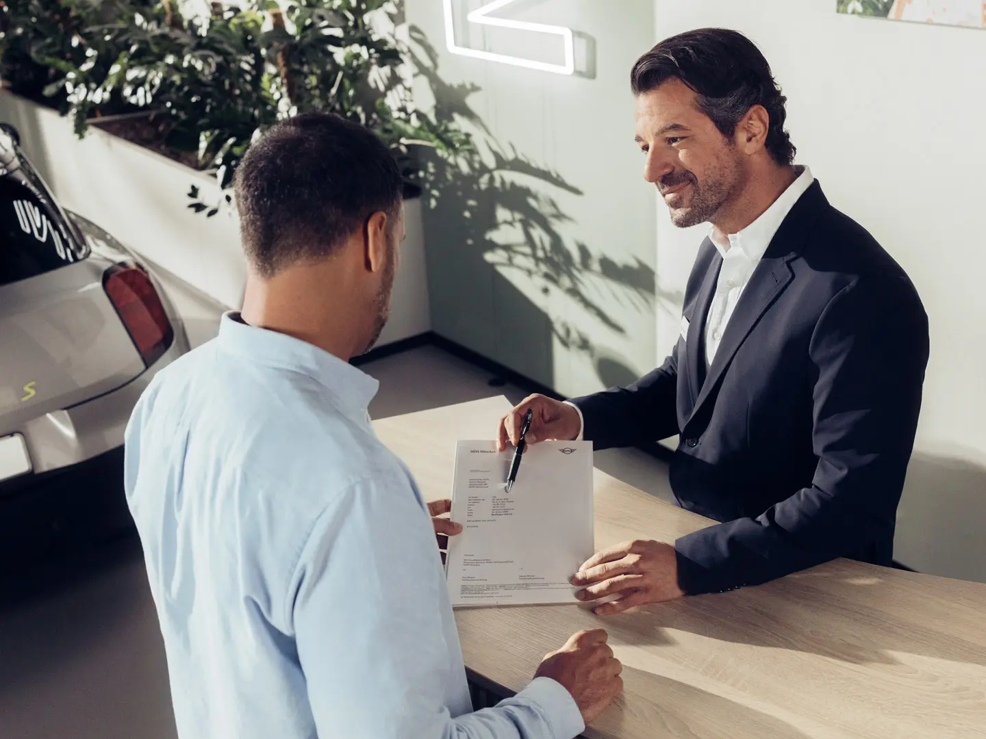 Asystent serwisowy Partnera MINI omawia z klientem opcje ubezpieczenia opon MINI.