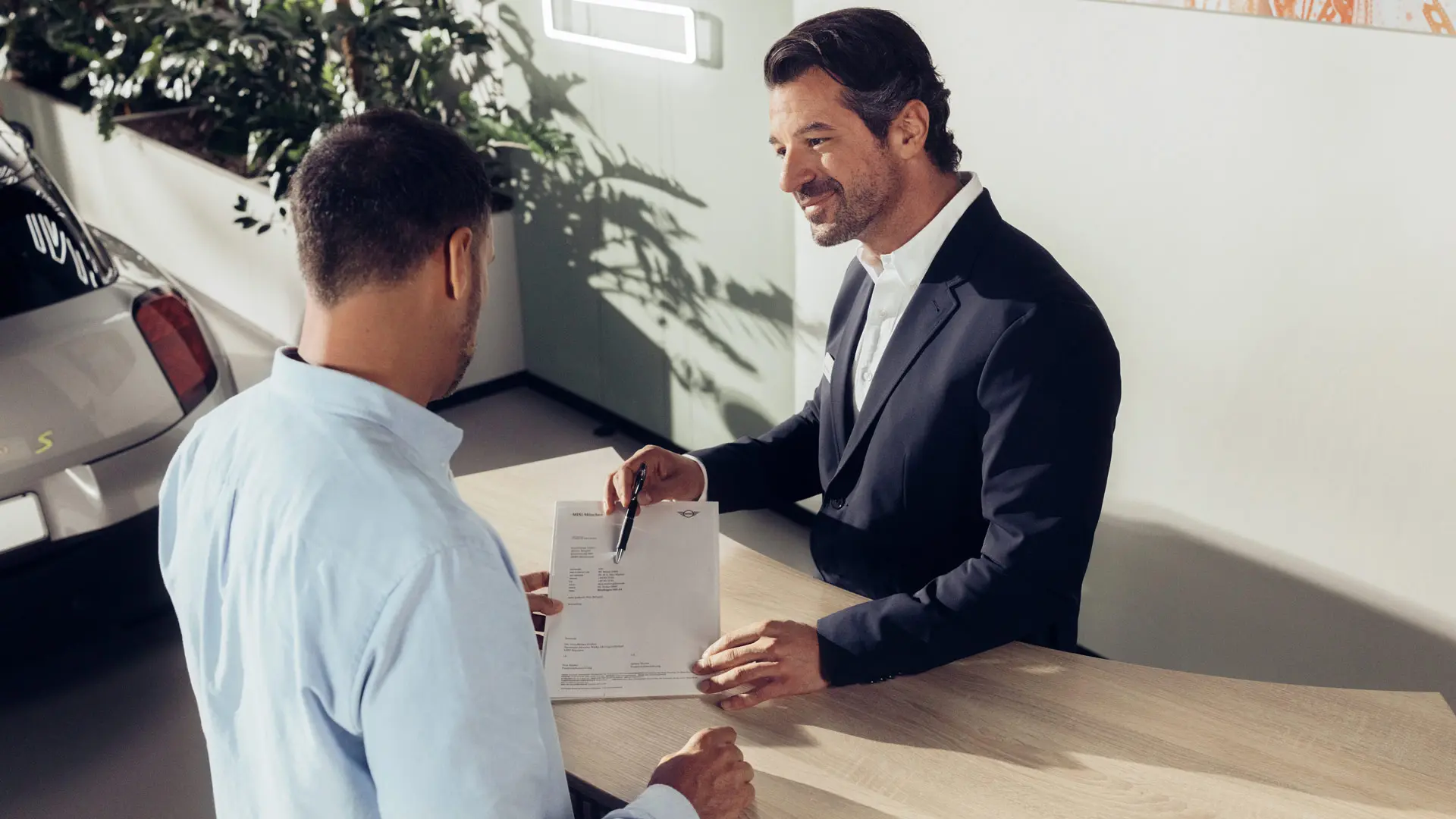 Asystent serwisowy Partnera MINI omawia z klientem opcje ubezpieczenia opon MINI.