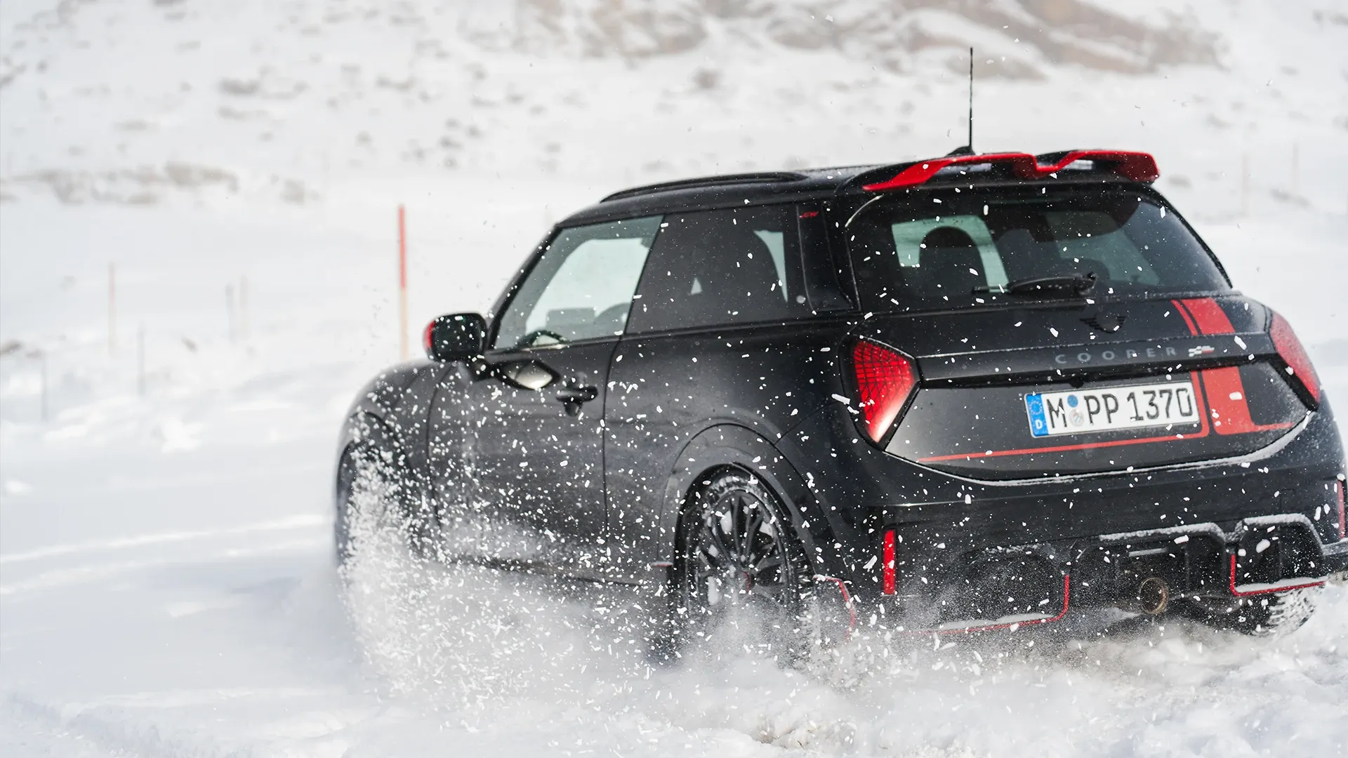 Widok z tyłu na MINI Cooper JCW podczas jazdy po śniegu.