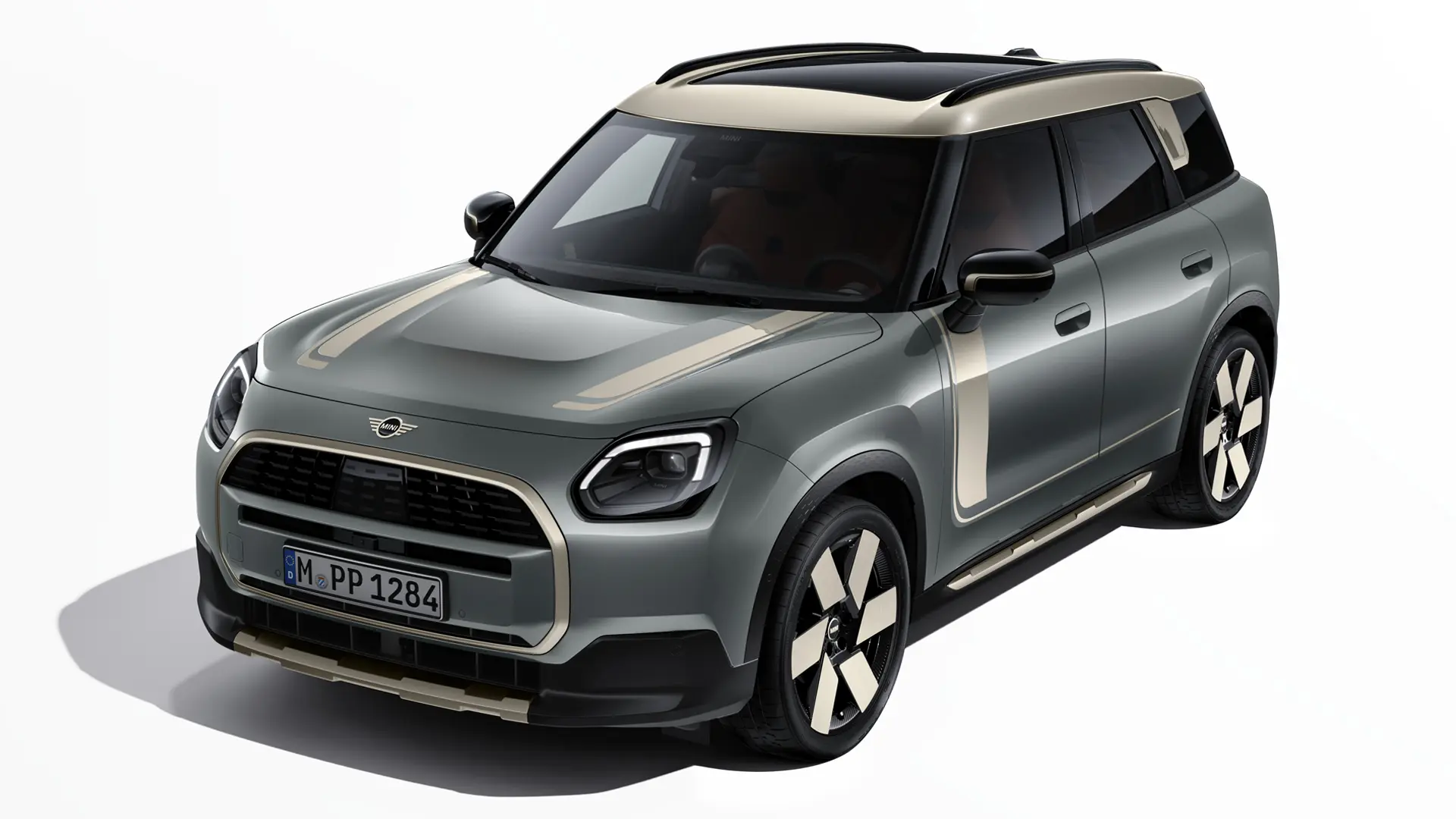 MINI Countryman Electric w kolorze Smokey Green z naklejkami MINI Favoured w kolorze Vibrant Silver, widok w trzech czwartych.