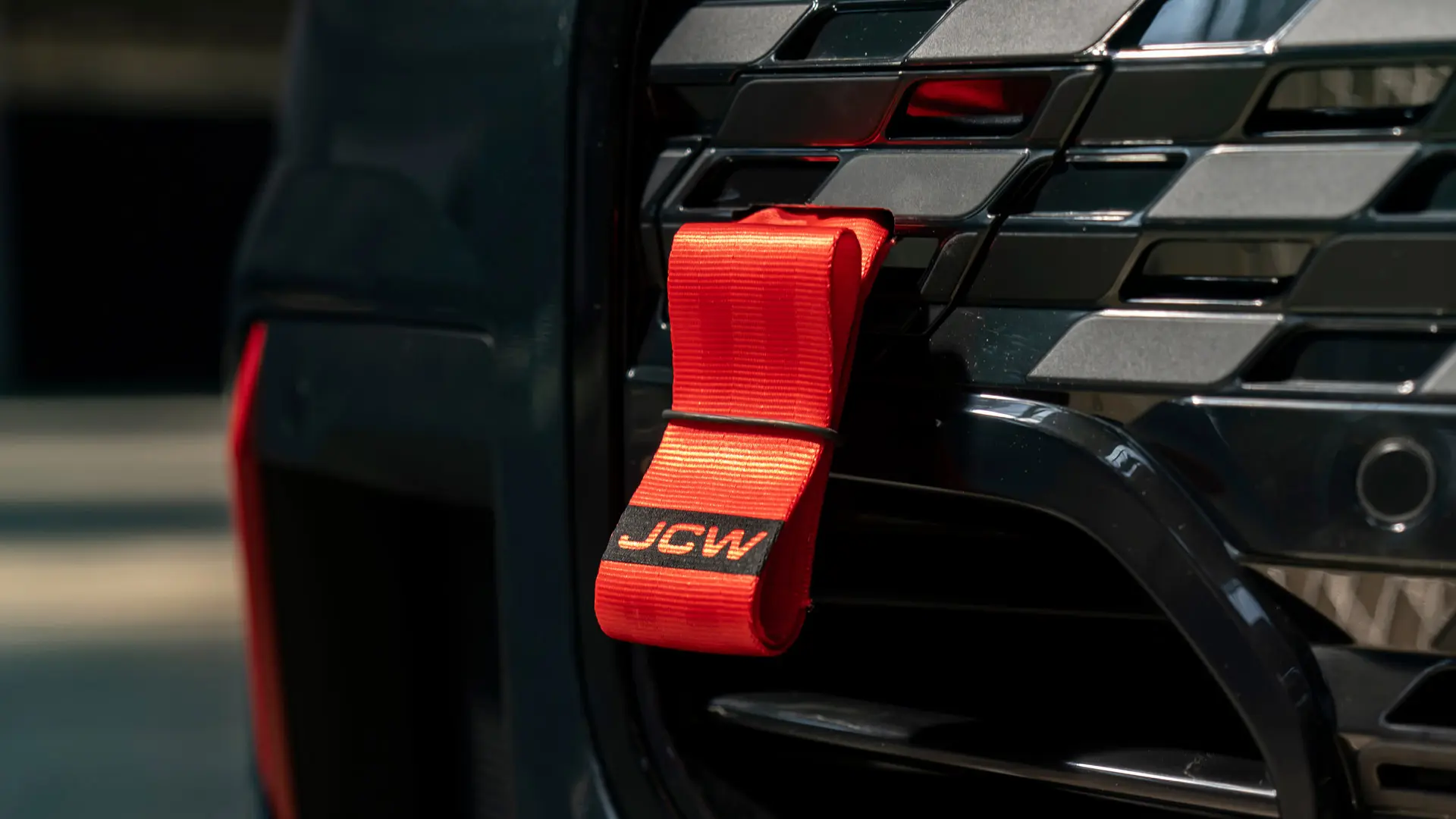 Czerwony pas holowniczy MINI John Cooper Works z czarnym logo JCW o długości trzpienia 90 mm.