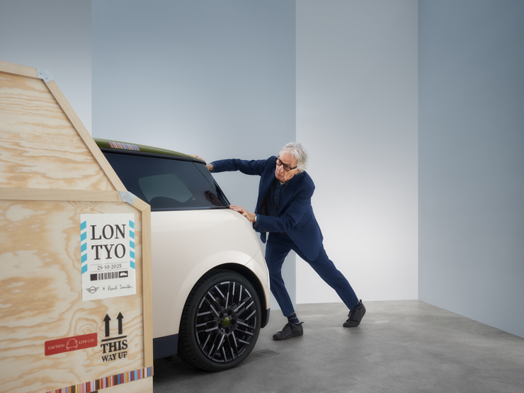 Widok z tyłu w pełni elektrycznego MINI Cooper Paul Smith Edition w kolorze Inspired White z Paulem Smithem za samochodem